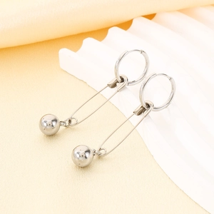 Detailed view of silver stainless steel safety pin earrings with a bead drop on fabric