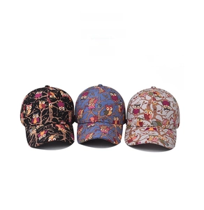 Detailed display of three woodpecker print baseball caps in black, blue, and light grey