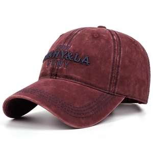 Close-up of vintage washed denim baseball cap with intricate burgundy letter embroidery