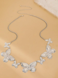 Detail of silver butterfly waist chain with metallic embossing on beige background