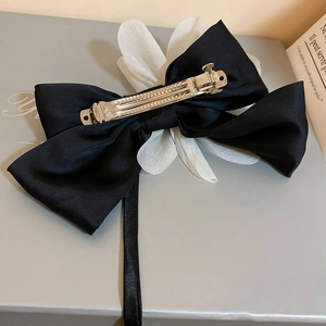Elegant black satin bow hair clip with white flower petal and silver metal spring fastener