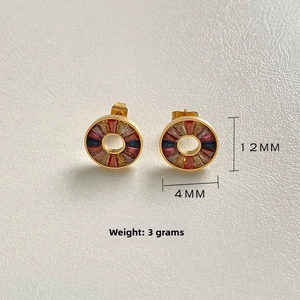 Macro detail of 12mm gold titanium earrings with multi-color cubic zirconia inlay