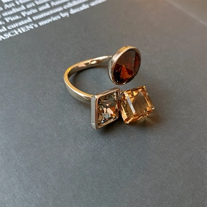 Macro detail of gold plated open ring with geometric amber and grey zircon stones
