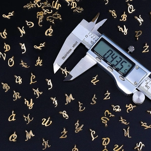 Golden metal alphabet pendant measurement showing size K charm with digital caliper