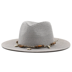 Detail of grey straw sun hat featuring bohemian wood beads and shell decorations