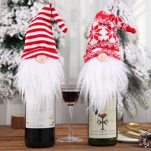 Christmas gnome wine bottle covers with knitted hats and white faux fur beards on a table