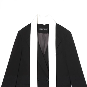 Blazer noir pour femme avec revers foulard blanc contrasté, vue à plat professionnelle