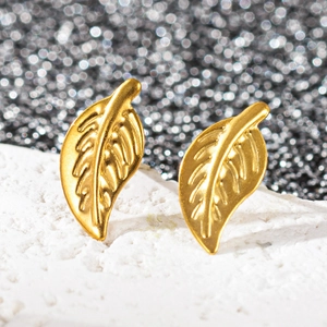 Vue macro de boucles d'oreilles feuilles dorées 18 carats avec texture nervurée détaillée