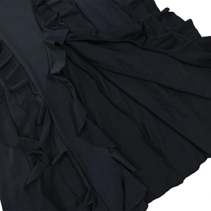 Vue détaillée des volants noirs et des coutures plissées sur la jupe de la robe longue