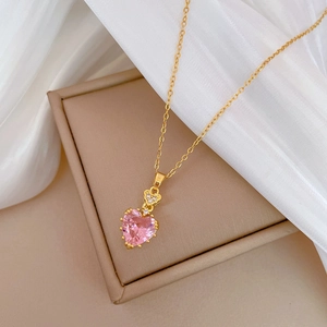 Luxurious gold necklace with pink heart zircon pendant on white silk background