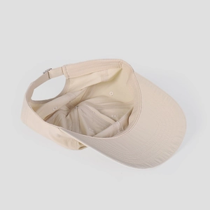 Detail view of adjustable metal buckle and inner sweatband on a beige baseball cap