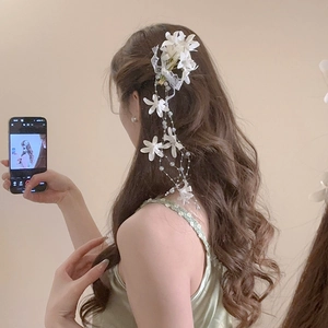 Detailed view of floral hair clip with delicate lace petals and elegant pearl tassels