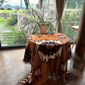 Detail of bohemian geometric woven blanket with tassels used as a round tablecloth