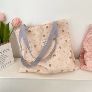 Detailed texture of pink quilted tote bag with cute cartoon bear prints and purple straps