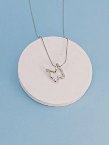 Macro detail of a silver stainless steel hollow butterfly pendant on a snake chain