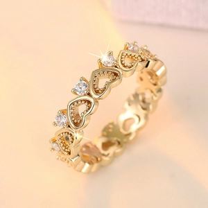 Macro shot of gold-plated heart-shaped ring with sparkling white cubic zirconia stones