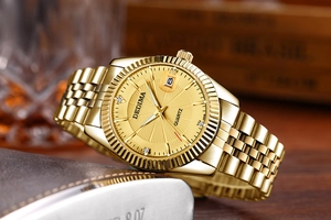 Close-up of golden quartz watch with fluted bezel and date window on a luxury background