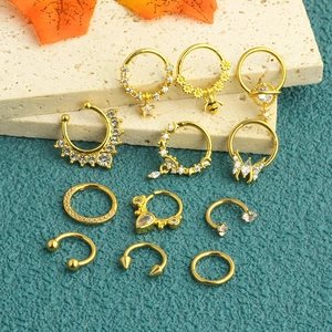 Detailed set of golden surgical steel nose rings with zircon, bee, and crown charms