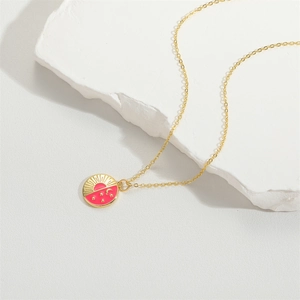 Minimalist gold necklace with pink celestial sun moon and star pendant on stone