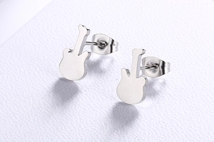 Macro shot of silver guitar-shaped stainless steel stud earrings on a white texture