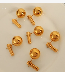 Detail of 18k gold plated titanium steel earrings with sphere and cylinder design