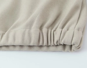 Détail des poignets élastiques côtelés et texture molletonnée douce sur survêtement beige