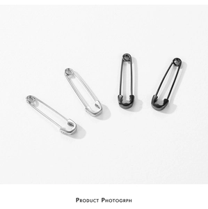 Macro shot of S925 sterling silver safety pin earrings in silver and black finishes