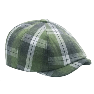 Macro detail of dark green plaid fabric texture and top button on a British beret hat