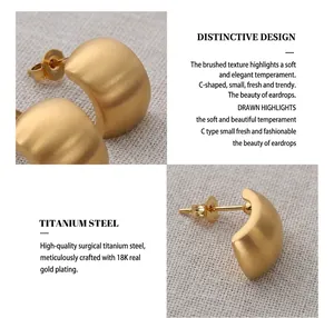 Detailed macro view of C-shaped 18K gold plated titanium steel earrings with brushed finish