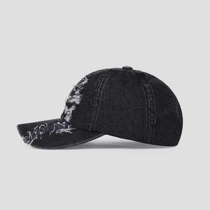 Detailed side view of vintage distressed black denim baseball cap with frayed hole design