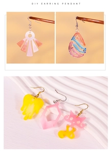 Macro detail of DIY acrylic earring pendants in heart, cat, and geometric shapes with gradients