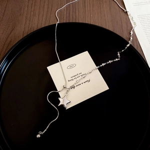 Detail of silver star pendant necklace with snake chain on a black jewelry display tray