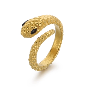 Bague serpent dorée avec texture d'écailles et yeux en pierres noires sur fond blanc
