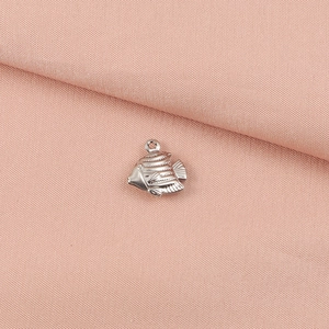Macro shot of a silver whale fish pendant showing detailed textures on a pink fabric