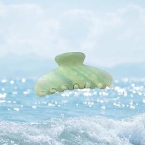 Pince à cheveux en acétate vert clair avec design coquillage et texture marbrée