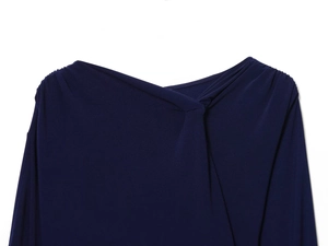 Detailed view of the dark blue knitted dress showing a twisted knotted neckline and pleated fabric