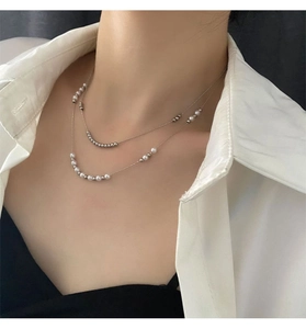 Double-layered titanium necklace with silver beads and pearls shown on a model neck