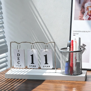 Minimalist desk calendar and pen holder with silver metal stand and white base