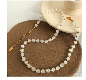 Macro detail of cat eye stone beads with gold spacers and adjustable lobster clasp