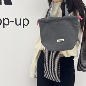 Close-up detail view of a stylish gray woolen polka dot drawstring tote handbag.