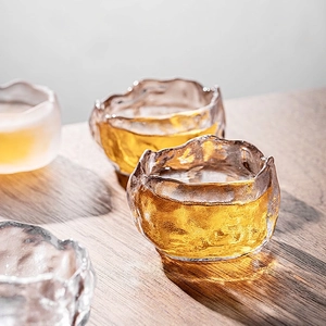 Handcrafted Japanese glass tea cup with ice-crack texture and hammered finish on wood