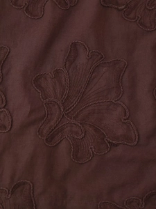 Détail macro du tissu marron de haute qualité avec broderies florales 3D complexes