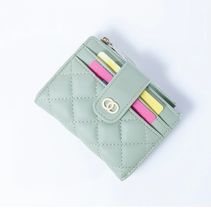 Detail of light green quilted wallet featuring gold double-ring clasp and card slots