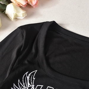Close-up of black ribbed long sleeve crop top with white print and crew neck detail