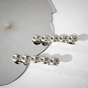 Set of two silver metallic barrette hair clips with retro coffee bean link design