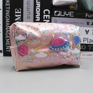 Pink glitter makeup bag with space patterns and star travel text on a book background
