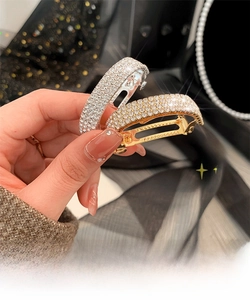 Detailed macro shot of sparkling rhinestone ponytail clips in gold and silver finish