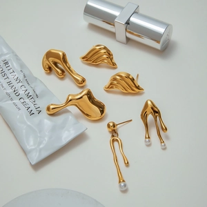Golden lava earrings set with fluid geometric shapes and elegant pearl accents