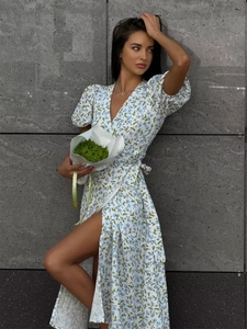 Detailed close-up of floral print cotton dress with puff sleeves and side slit design