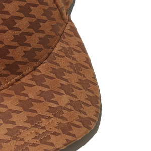 Close-up of brown houndstooth baseball cap fabric showing stitching and texture